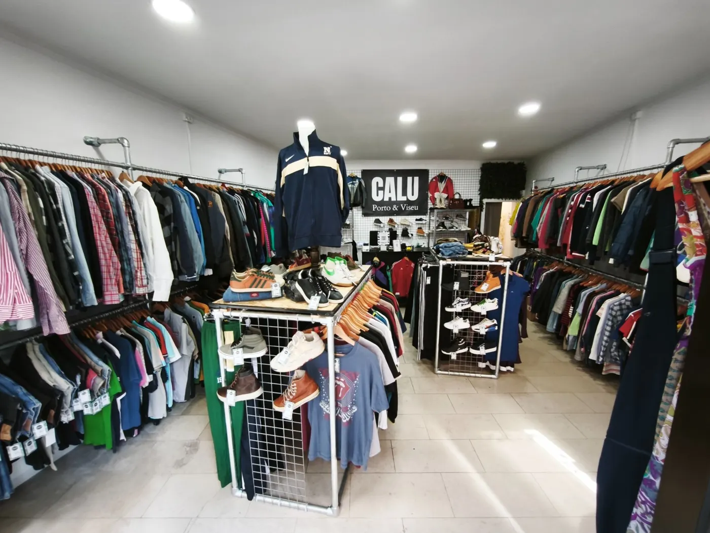 Interior da CALU Porto com araras de roupa e ténis
